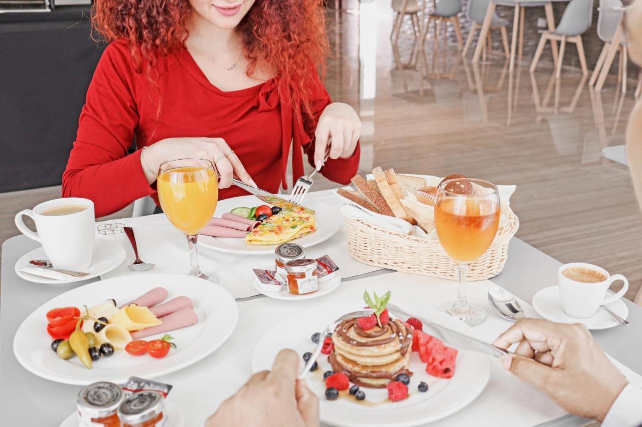 דוחה The Bentley Luxury Hotel & Suites מראה חיצוני תמונה A woman eating breakfast